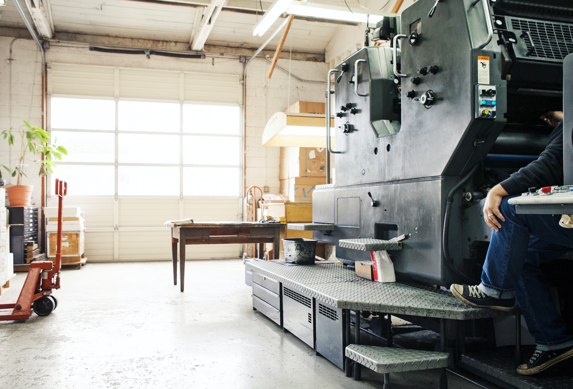 Male Worker Operating Printing Machine At Workshop